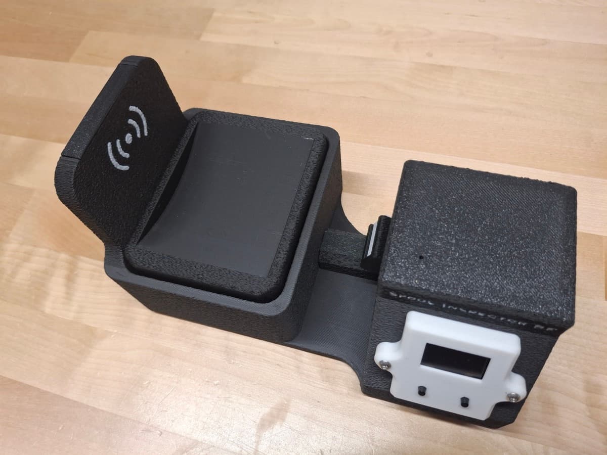 Spool Inspector RF — assembled black unit with the NFC wave symbol on the scale cradle and the OLED electronics box alongside